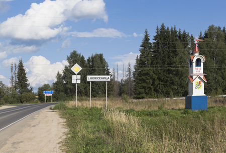 Sign and a stele at the entrance to the village of Nyuksenitsa, Vologda region, Russiaのeditorial素材