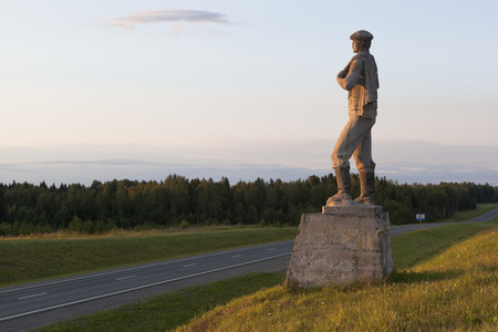 Filinskaya, Syamzhensky District, Vologda Oblast, Russia - July 8, 2019: Monument to the worker at sunset near the M8 highway, near the village of Filinskayaのeditorial素材
