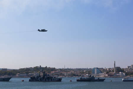 Sevastopol, Crimea, Russia - July 28, 2019: Be-12 anti-submarine amphibious aircraft flies over the parade system of warships at the celebration of Navy Day in Sevastopol Bay, Crimeaのeditorial素材