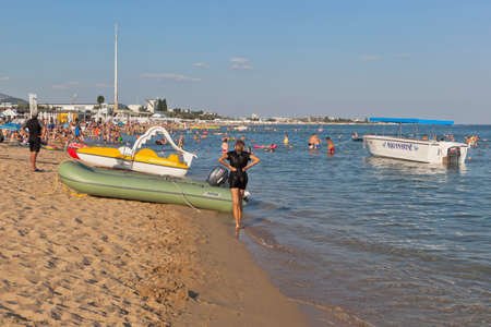 Zaozernoe village, Evpatoria, Crimea, Russia - July 18, 2021: Boats and pedal boats on Surer Aqua beach of Zaozernoye resort village, Evpatoria, Crimeaのeditorial素材