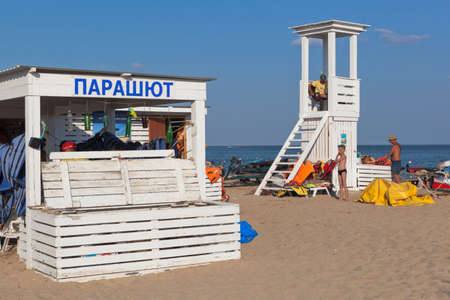 Zaozernoye, Saksky district, Crimea, Russia - July 18, 2021: Parachute flight booking place and rescue tower on the Super Aqua beach of the resort village of Zaozernoye, Saksky district, Evpatoria, Crimeaのeditorial素材