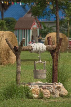 water well, rope and wooden bucket 