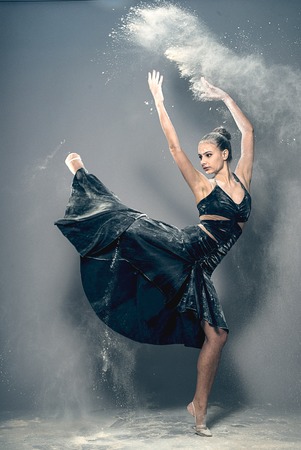 Girl dancing with a flour in black dressの写真素材