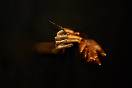gold hands witn brush isolated on black background