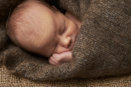 newborn girl sleeps on sackcloth, portrait, flowers, brown