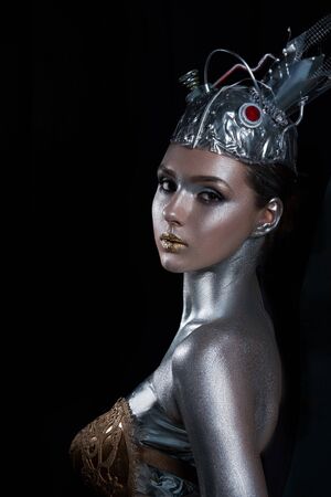 young, beautiful girl with silver skin in a crown and gold armorの写真素材