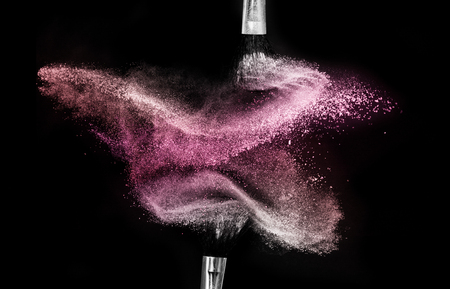 brush with red cosmetic powder spreading for makeup artist and graphic design in black backgroundの写真素材