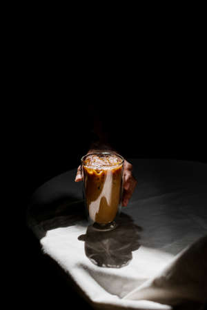 Close-up glass of iced coffee with milk on the tableの写真素材
