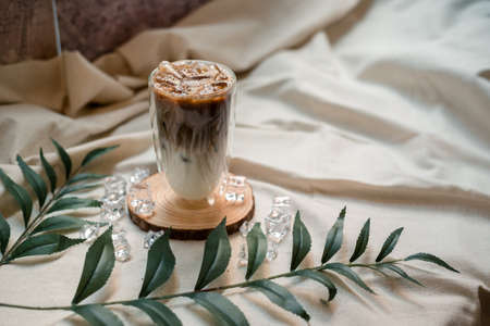 Close-up glass of iced coffee with milk on the tableの写真素材