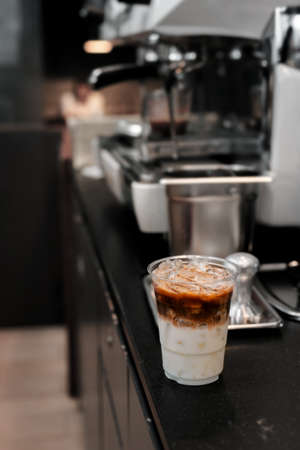 Close-up glass of iced coffee with milk on the tableの写真素材