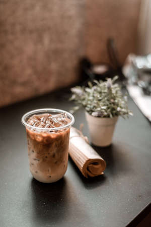 Close-up glass of iced coffee with milk on the tableの写真素材