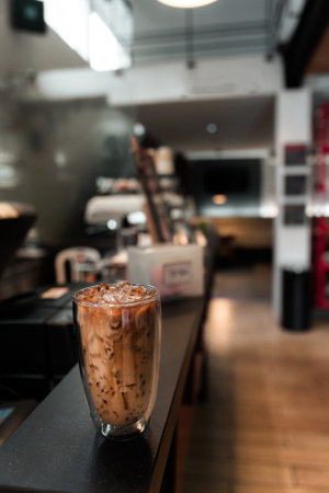 Close-up glass of iced coffee with milk on the tableの写真素材