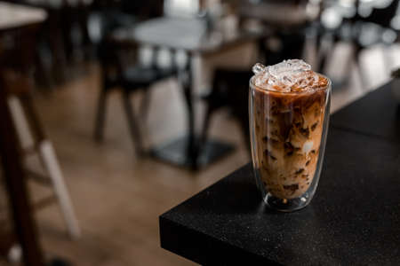 Close-up glass of iced coffee with milk on the tableの写真素材
