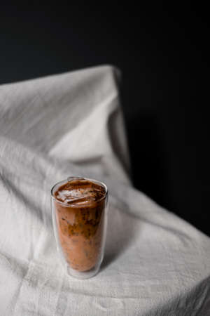 Close-up glass of iced coffee with milk on the tableの写真素材
