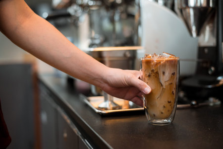 Close-up glass of iced coffee with milk on the table