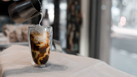 Close-up glass of iced coffee with milk on the table