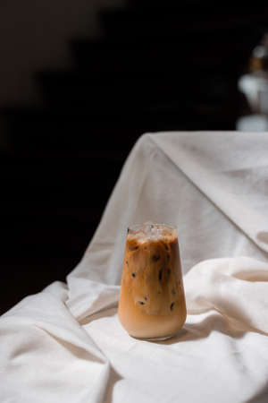 Close-up glass of iced coffee with milk on the tableの写真素材