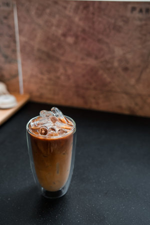 Close-up glass of iced coffee with milk on the table