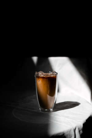 Close-up glass of iced coffee with milk on the tableの写真素材