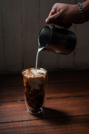 Close-up glass of iced coffee with milk on the table