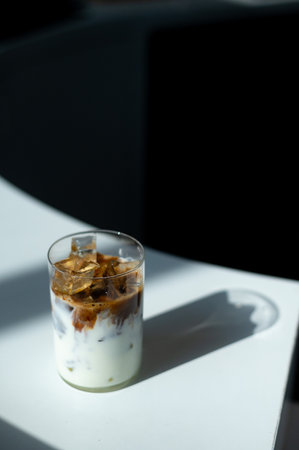 Iced coffee with milk in a glass on the table, stock photoの写真素材