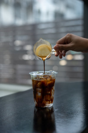 Coffee pouring into plastic cup on table in coffee shop.の写真素材