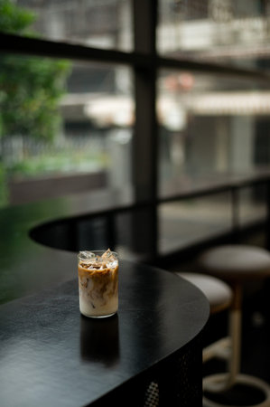 Iced coffee latte on wood table with bokeh backgroundの写真素材