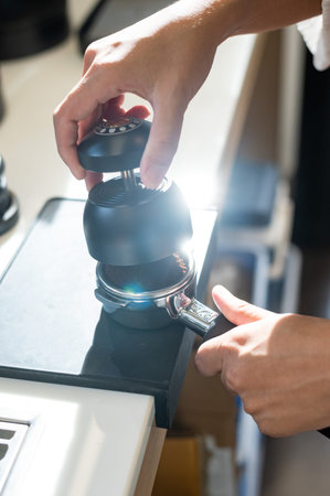Close-up of barista using coffee machine in coffee shop.