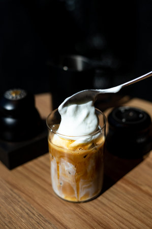 Iced coffee with milk in glass on wooden table, stock photo