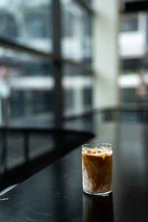 Iced coffee in glass on table in coffee shop, stock photo