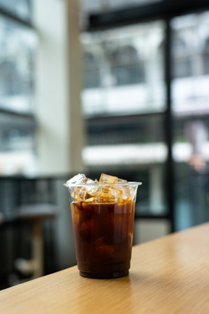 Iced coffee with ice cubes on wood table in coffee shop.の写真素材