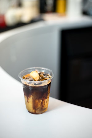 Iced coffee in plastic cup on table in coffee shop, stock photoの写真素材