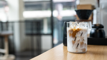 Iced coffee in glass on wood table and Coffee shop blur background