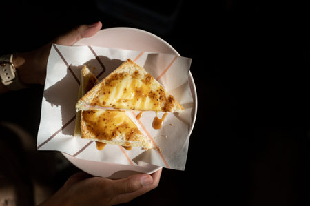 Sandwich with cheese and ham in a paper cup on the table