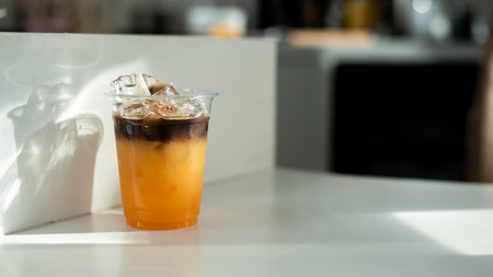Iced coffee in plastic cup on white table in coffee shop.の写真素材