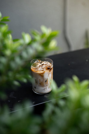 Iced coffee in a glass on the table. Selective focus.