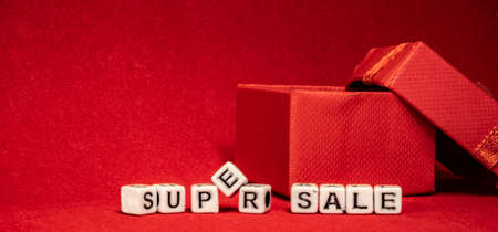 super sale banner on red background with white letters cubes and gift boxの写真素材
