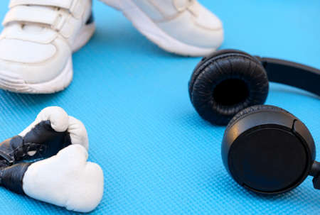 sport fitness concept, space for text, black sneakers, blue dumbbells, headphones, fitness jump rope on blue background templateの写真素材