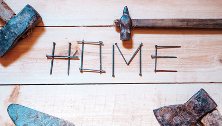 the concept of repairing a wooden house with their own hands top view close-up. Home is written with...