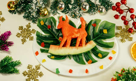 CLose-up 2021 symbol of new year cow bull, watermelon bull on dried oranges on Christmas festive table, new year christmas food. holiday, celebration.の写真素材