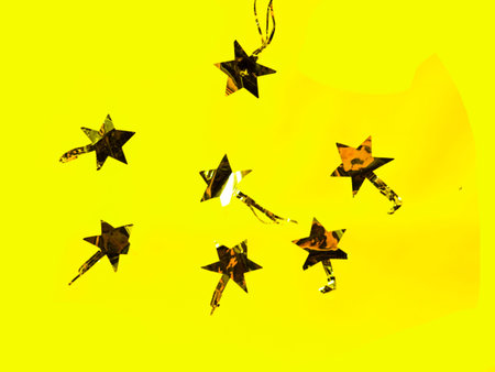 Gold stars sparkles on a trendy yellow background. Festive background for your projects. Flat lay,...