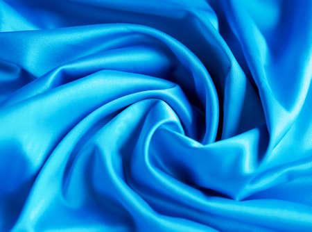 Smooth elegant blue silk or satin luxury cloth texture can be used as abstract background. Crumpled fabric Twisted at the sideの写真素材