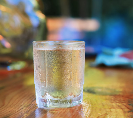 glasses of vodka with various snack on wooden table