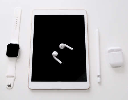 white tablet with pencil wireless headphones with case smart watch on white tableの写真素材