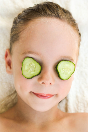 Close up of beautiful girl with facial mask of cucumber の写真素材