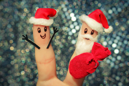 Face painted on fingers. Santa Claus gives gifts. Toned imageの写真素材