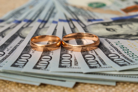 Wedding rings on the background of moneyの写真素材