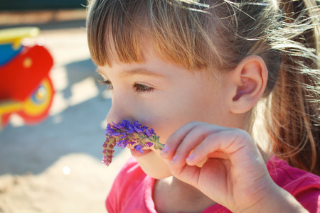 Little girl smelling a flowerの写真素材