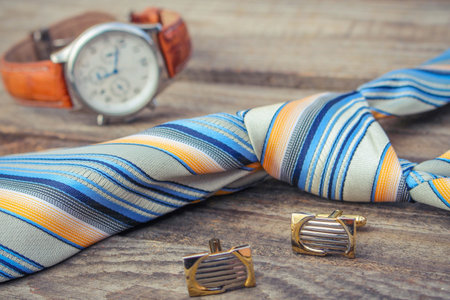 Tie, cufflinks and watches on the old wood background