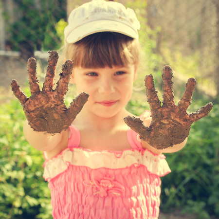 Girl shows her dirty hands. Toned imageの写真素材